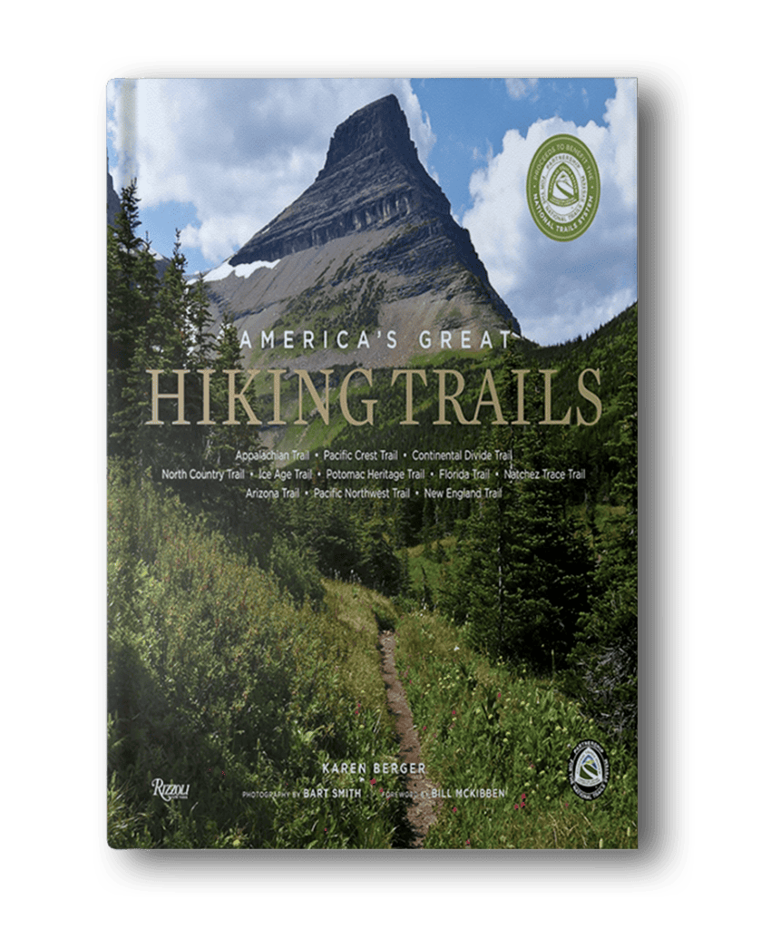 Cover of the book "America's Great Hiking Trails" featuring a mountain scene with lush greenery and a trail leading towards the mountain. Various trail names are listed across the cover, making it one of the most inspirational books for women who love adventure.