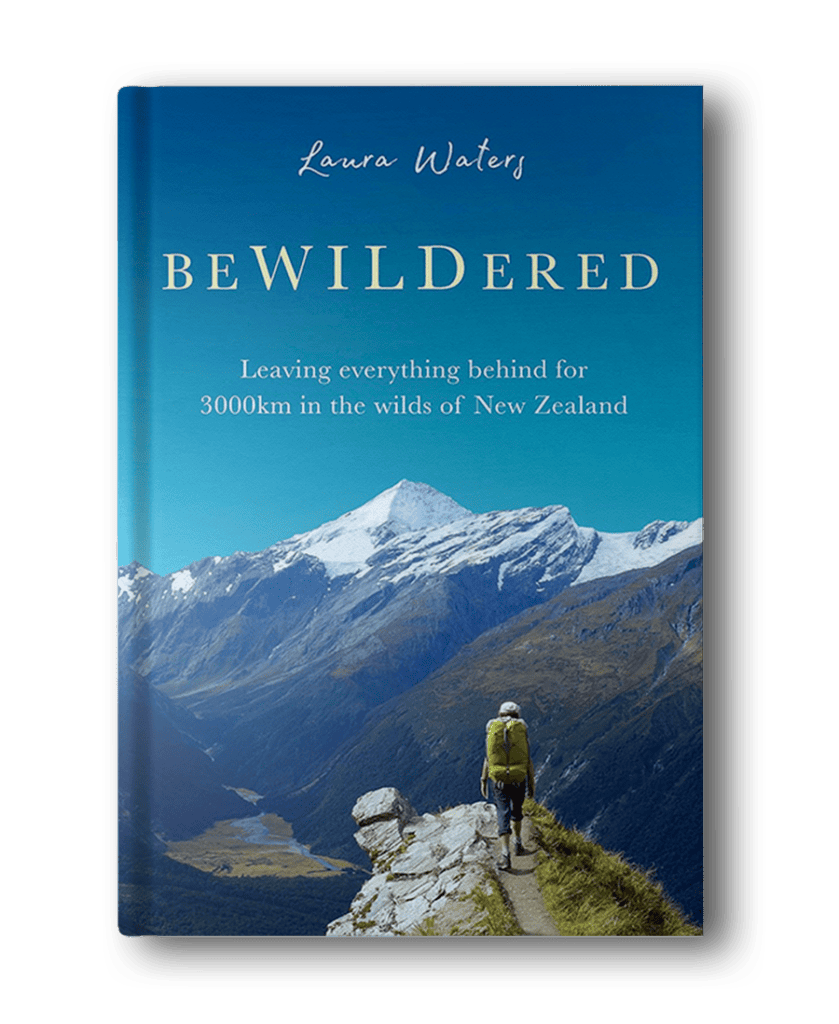 Book cover of "BeWILDered" by Laura Waters, featuring a hiker on a trail with snow-capped mountains and a blue sky in the background. The subtitle reads, "Leaving everything behind for 3000km in the wilds of New Zealand." A must-read among hiking books for women.