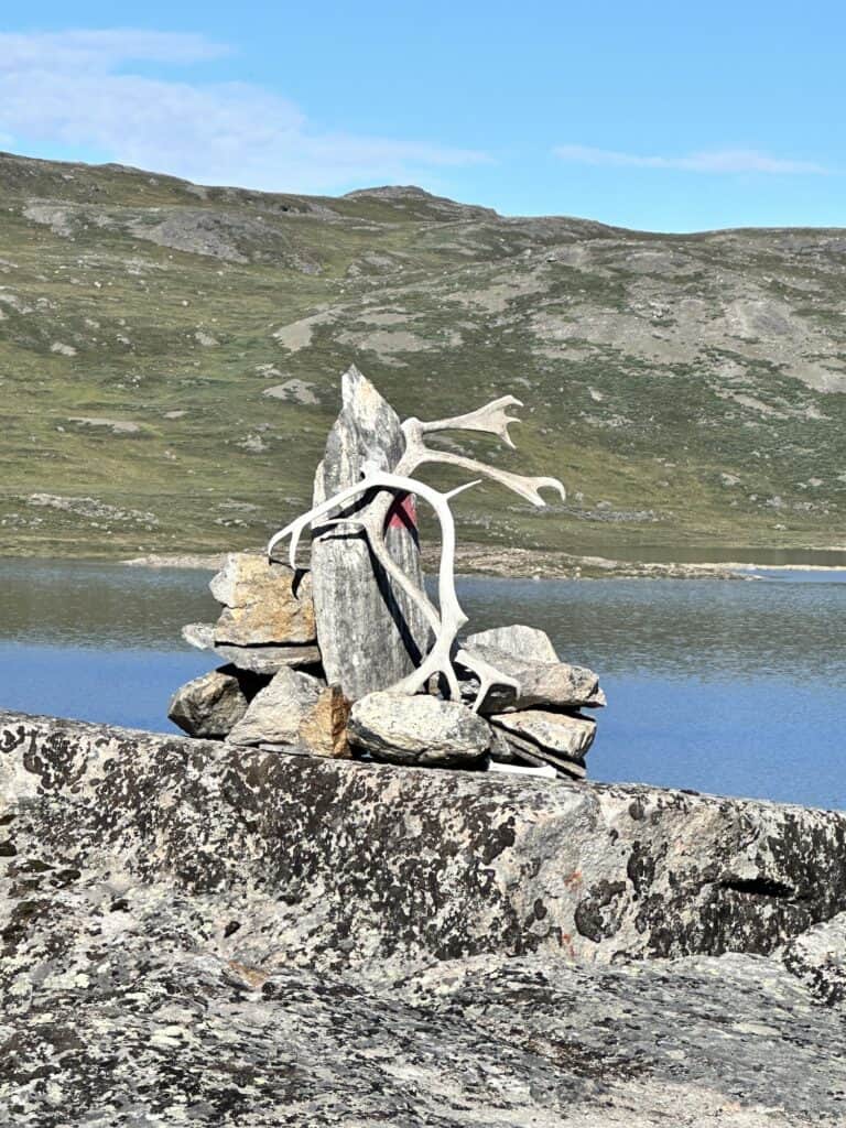 rock cairn on the arctic circle trail with a lake in the distance