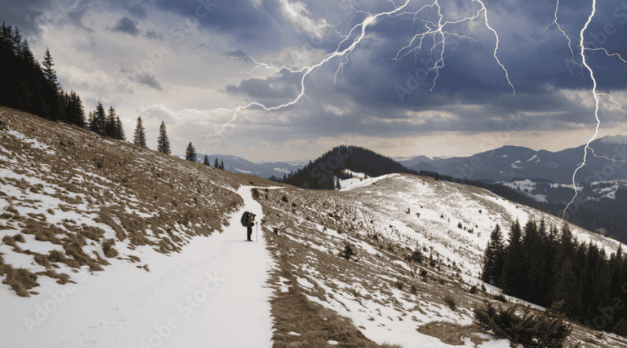 Hiker on snowy ridge in storm